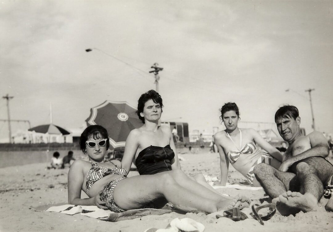 Grupo de tres adultos uruguayos revisando juntos un álbum de fotografías antiguas